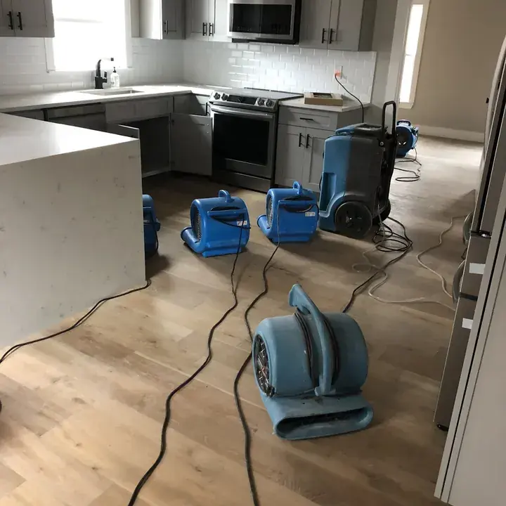Air movers drying an exposed subfloor in a Lake Travis Hill Country home