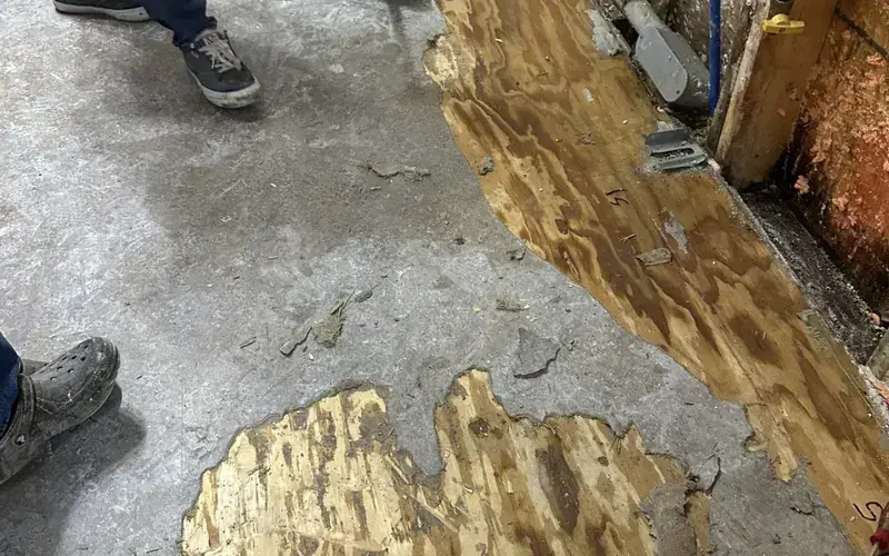 Flooring pulled up to reveal water under the slab in a Spicewood, TX home