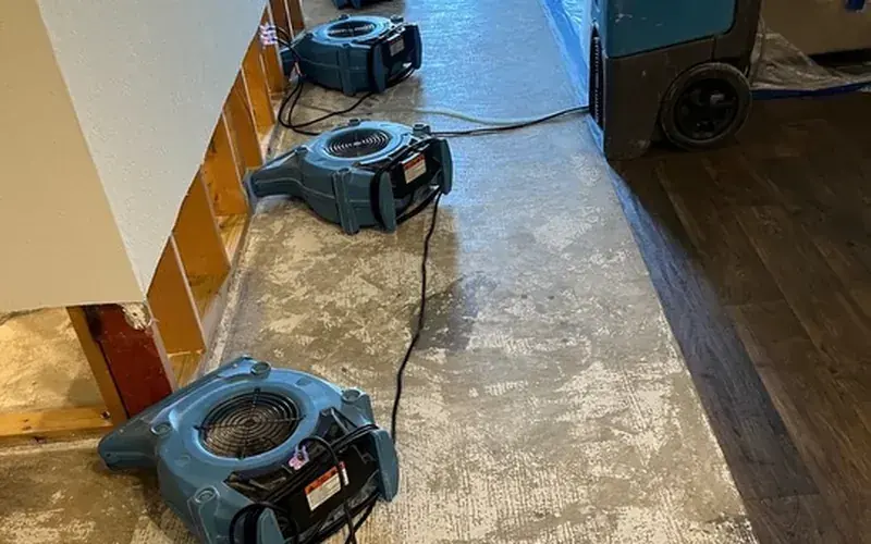 Air movers and a dehumidifier drying a Spicewood, TX floor